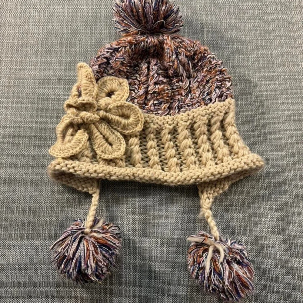 Multicolored knitted hat with pom poms